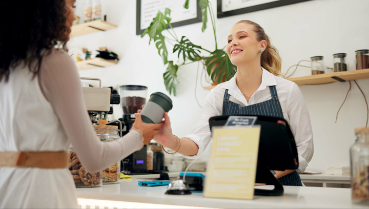 Cashier handing customer coffee